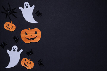 Pumpkins, spiders and ghosts on black background. Halloween holiday. For backgrounds and presentations