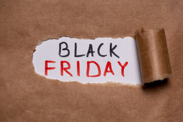 The word “Black Friday” appearing behind the torn paper. Black Friday and the sale