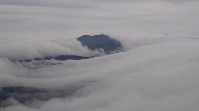 A solid stream of fog in the mountains. Timelapse.