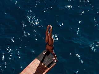 female diver in handstand, preparing to dive from platform