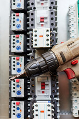 electric screwdriver on the background of magnetic starters
