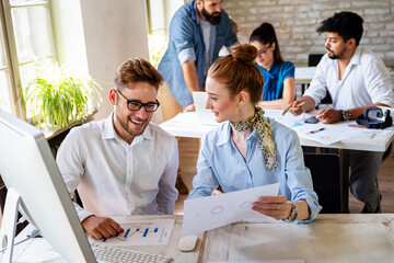 Group of young multi-ethnic startup business team collaborating on project in modern office
