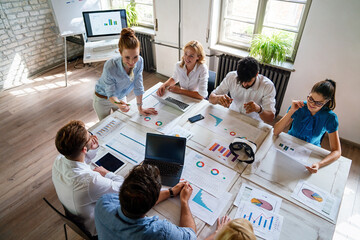 Group of young multi-ethnic startup business team collaborating on project in modern office