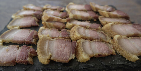 Torrezno cortado y servido en plato de pizarra típico de Albacete