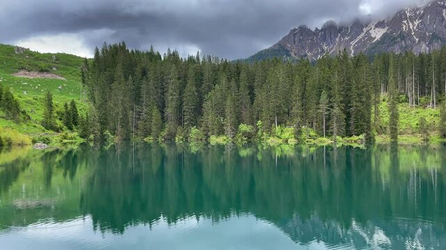 Lago di Carezza or Karersee in South Tyrol during an overcast day in the Dolomits in Italy.