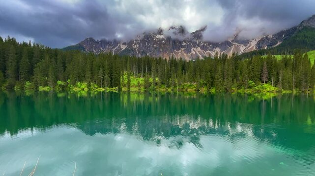 Lago di Carezza or Karersee in South Tyrol during an overcast day in the Dolomits in Italy.