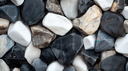 A collection of smooth, black and white stones arranged naturally, highlighting their varied textures, shapes, and the contrasting beauty found within natural formations.