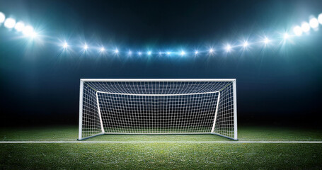 A large football stadium with goals in the middle, illuminated by floodlights.