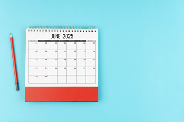 June desk calendar for 2025 year with pencil on blue background, Position with copy space.