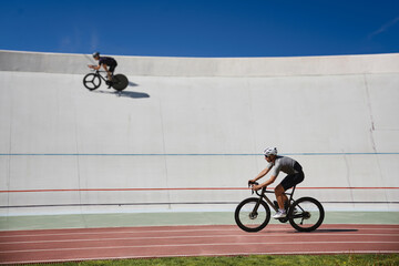 Two healthy man cyclists exercising on bicycles on sprint track