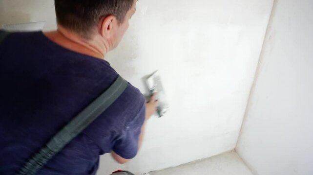 The process of applying putty to the wall.