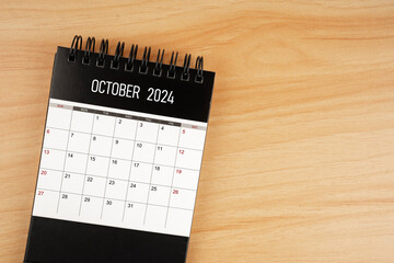 October desk calendar for 2024 year on wooden floor.