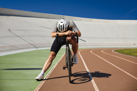 Tired exhausted bicyclist athlete stopped after hard cycling training