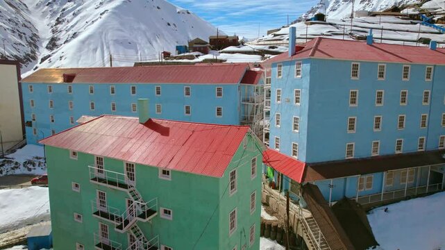 Drone Fly Sewell Chilean Colorful Andean Cordillera mountains mining town, architecture around snowy environment
