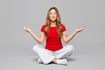 Full body young woman she wear red t-shirt casual clothes sits hold spreading hands in yoga om aum...