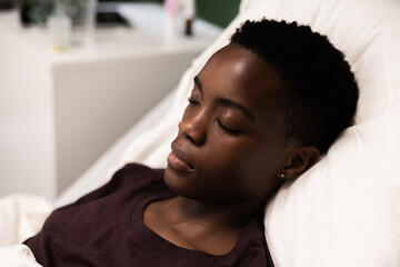 A girl resting peacefully in a hospital bed, eyes shut in calm