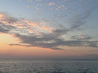Gentle Sunset Over Calm Ocean with Pink Clouds