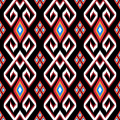 Bold ethnic Ikat pattern featuring red, white, and gold geometric shapes with diamond and heart motifs on a black background. Ideal for fabric design, home decor, and fashion with a tribal-inspired 