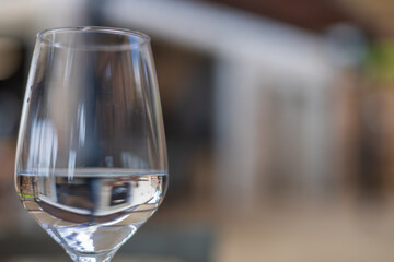 A wine glass is filled with water and stands on the table