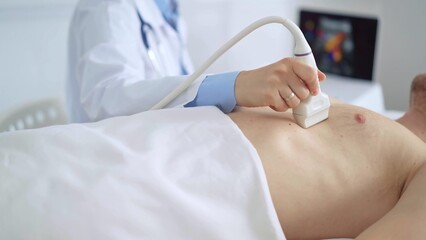 Doctor woman performing breast and heart ultrasound exam on man patient. Medicine service,...