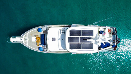 Aerial view from above of a large eco-friendly yacht with solar panels receiving energy during the...