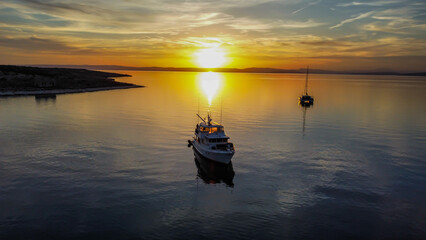 aerial view sunset at the sea with two yachst and very peacefull sea. drone view
