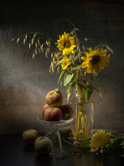 Still life with a bouquet of sunflowers and apples on an old wooden table