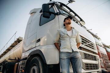 View from below, standing and posing. Truck driver is near the transport outdoors
