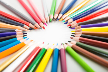 Fototapeta premium Colored pencils lying around the heart
