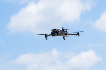 Modern drone in blue sky. Flying a quadrocopter helicopter drone in the air, in a clear blue sky. 