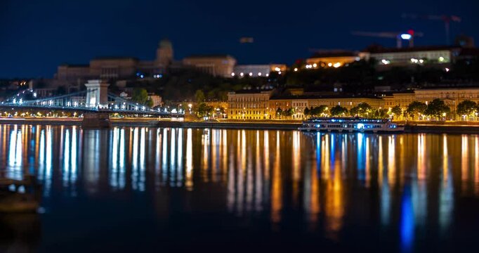 Budapest, Hungary - August 10, 2024: Buda castle and Chain bridge at night. Focus tilted to the Sztehlo Gabor street. Time-lapse, slide transition.