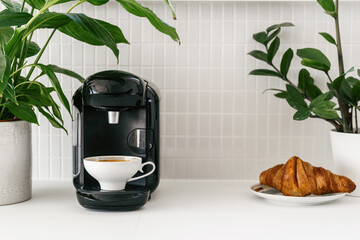 Kitchen corner with coffee maker, cup and a fresh croissant