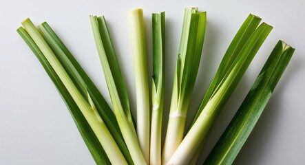 Obraz premium Detailed closeup of fresh lemongrass leaves against a clean white backdrop
