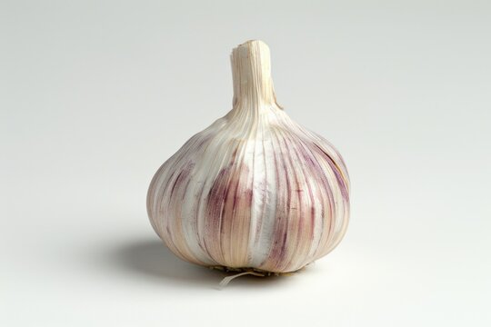 Close-up shot of a garlic bulb on a white surface, useful for cooking or health-related content