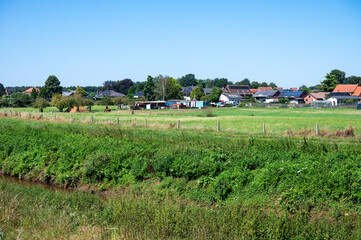 Green meadow and house backyards at the Flemish countryside in Halen, Limburg, Belgium