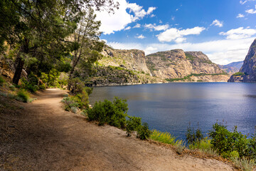 The Tueeulala and Wapama Falls, Kolana Rock, and Hetch Hetchy Dome are visible from the Wapama Falls Trail along the Hetch Hetchy Reservoir in Yosemite National Park.