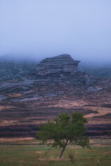 Bizarre layered rocks in the fog, this is the Kazakh melkosopochnik, Monastic mountains in eastern Kazakhstan in autumn.