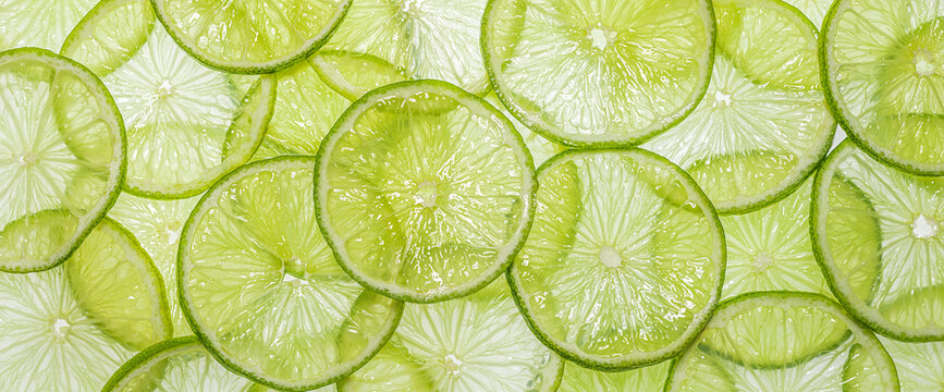 Juicy texture and fresh green color of lime slices on light background.