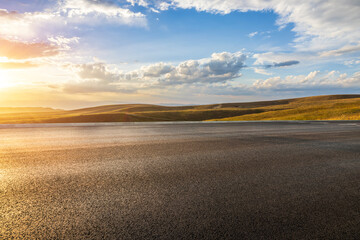 Asphalt road and beautiful grassland with mountains nature landscape in autumn. Road trip