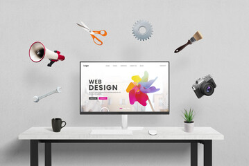 Web design concept page displayed on computer in studio, surrounded by creative, marketing, and...