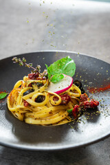 Spaghetti Carbonara with dried tomatoes and black olives Italian food