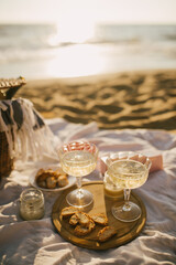 Beautiful summer picnic with champagne at sunset on the beach.