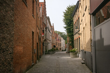 Fototapeta premium Cute empty brick house side street with no people in Bruges, Belgium
