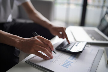 Fototapeta premium Man using calculator calculate finance and another hand holding pen