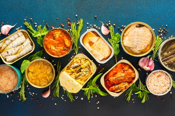 Different open tin cans with canned fish like salmon, mackerel, sprat, sardine, tuna, and herring,...