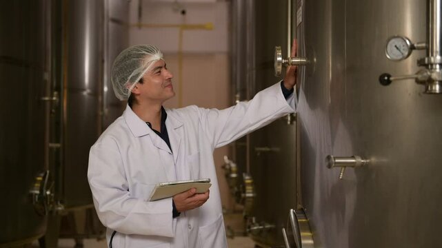 Professional winemaker controlling wine making process and quality at winery factory
