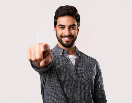 hombre joven sonriente se&ntilde;alando hacia el frente con un dedo sobre fondo blanco