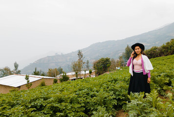  Foto de una feliz y bonita campesina con un sombrero hablando por un teléfono celular en los...