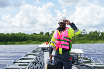 Obraz premium African-American engineer carefully examines cutting-edge floating solar panel system designed to harness renewable energy for complex industries