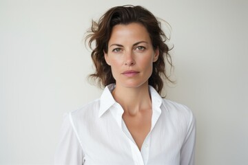 Fototapeta premium Portrait of a tender woman in her 40s wearing a classic white shirt in white background
